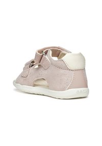 Sandali per bambini piccoli di colore rosa chiaro, realizzati in pelle con dettagli perforati, cinturino regolabile, suola in gomma bianca e parte posteriore chiusa per un supporto migliore.