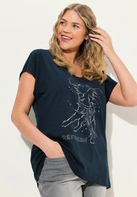 Námořnická modrá tričko s krátkým rukávem z měkké bavlny. Obsahuje bílé grafické provedení a slovo "REFRESH." Boční rozparky přidávají na designu.