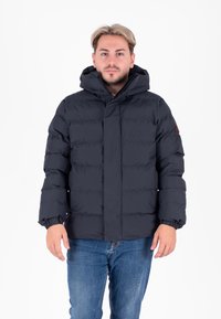 Donkerblauwe gewatteerde jas met een capuchon, uitgerust met elastische manchetten, een drukknoopsluiting aan de voorkant en een logopatch op de linker mouw.