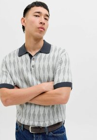 Šviesiai pilkas megztas trumpųjų rankovių polo marškinėliai su tamsiai pilku apykakle ir rankogaliais. Sukurtas su rombų raštu ir trimis mygtukais.