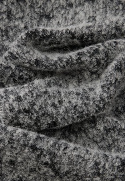 Υφασμάτινη υφή σε μαύρους και γκρι τόνους, που αναδεικνύει μια απαλή, αφράτη ποιότητα με μαρμαρωτό σχέδιο και ριχτή εμφάνιση.