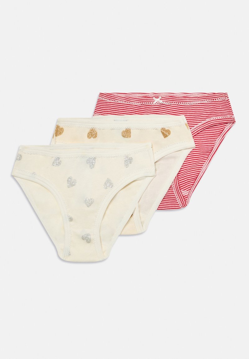 Three pairs of girls' underwear: two cream pairs with gold and silver hearts, and one red striped pair with a white bow accent.