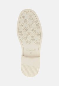 White rubber shoe sole featuring a raised pattern of interconnected logos. The brand name "GUESS" and size "37" are embossed.