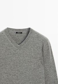 Szary sweter z dekoltem w serek wykonany z miękkiego dzianiny. Posiada ribbowany dekolt i gładką fakturę. Metka mówi "Massimo Dutti."