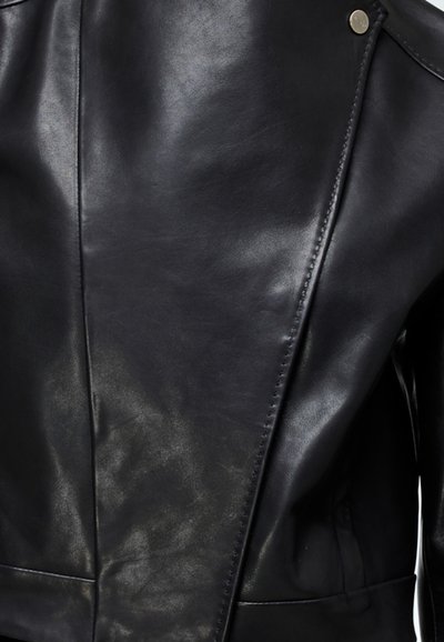 Černá kožená bunda s hladkým povrchem, přiléhavým střihem, asymetrickým uzávěrem a stříbrnými patentkami.