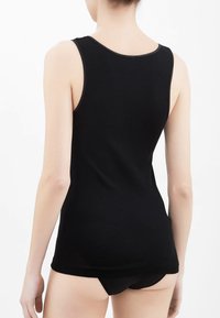 Top senza maniche nero realizzato in un tessuto morbido, con scollatura rotonda e texture soffice, dal design aderente.