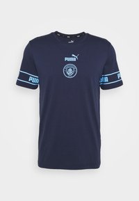 Marinblå Puma-t-shirt med Manchester City-logotyp och ljusblå Puma-logga över bröstet och ärmarna.