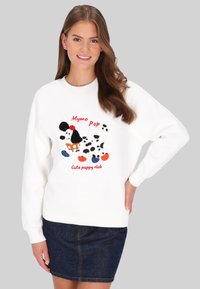 Sudadera blanca con un gráfico colorido de un cachorro con acentos en negro, naranja y azul. Diseño casual con puños y dobladillo acanalados.