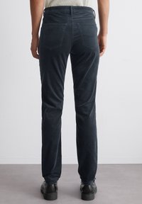 Donkerblauwe corduroy broek met een rechte pasvorm, voorzien van twee achterzakken en een riemlus in de tailleband. Gelaagd en gladde afwerking.