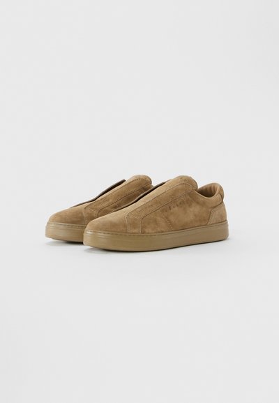 Pair of tan suede low-top slip-on sneakers with rubber soles on a plain light background.