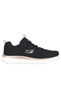 Chaussure de sport noire avec une tige en maille respirante, des accents métalliques dorés, une semelle blanche rembourrée et un design à lacets.