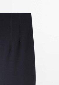 Jupe noire taille haute avec deux coutures verticales sur le devant, présentée sur un fond blanc uni.