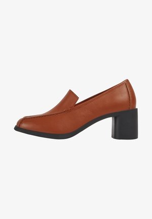 Chaussure à talon haut en cuir marron avec un bout arrondi, au design minimaliste et un talon bloc noir contrastant. Coutures décoratives sur l'avant.