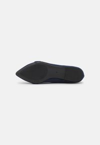 Scarpa in suede blu navy con punta affusolata, caratterizzata da una suola in gomma nera testurizzata e design minimalista. Ideale per abbigliamento formale o casual.