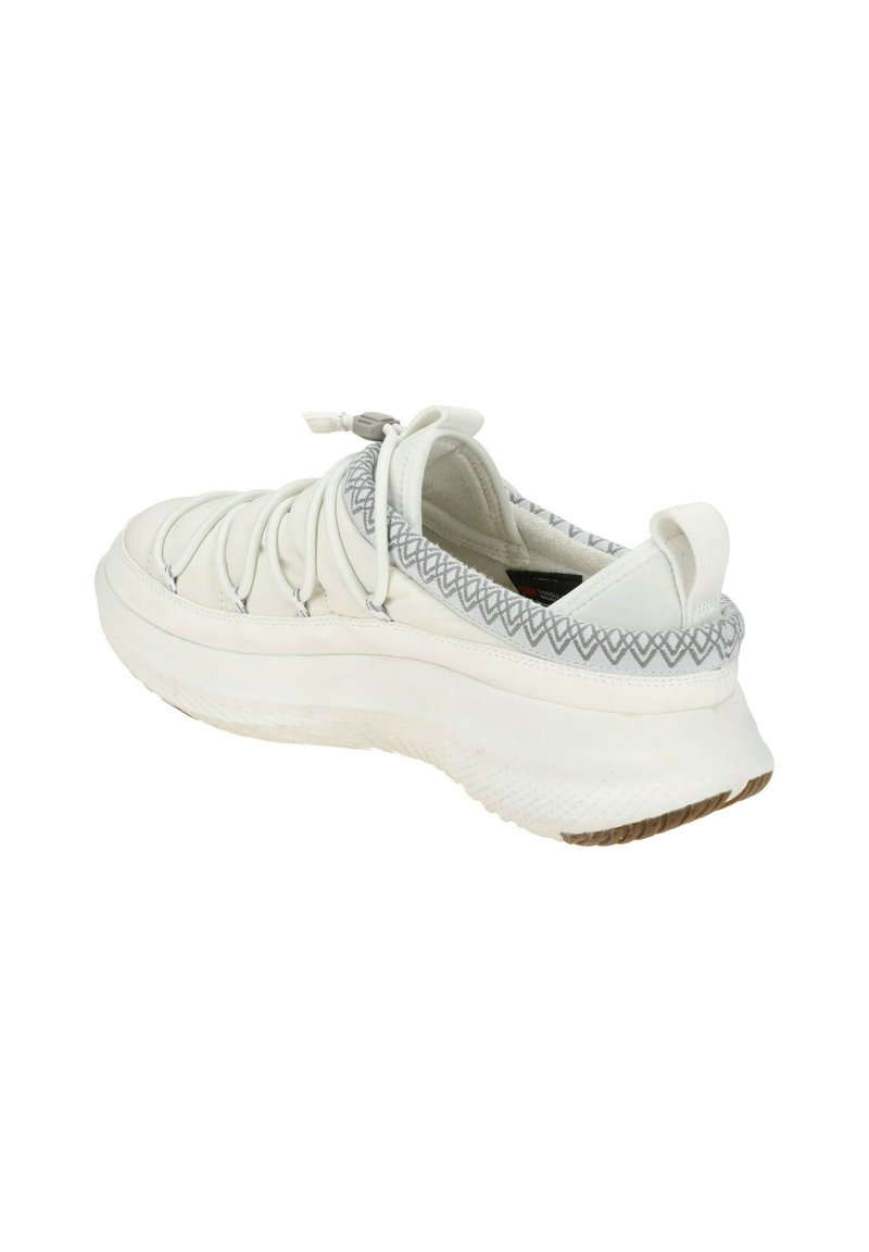 Witte sneaker met een bovenwerk van textiel en een rubberen zool. Kenmerkt zich door elastische veters en een gestructureerde accent rond de enkel. Rondingen bij de tenen.