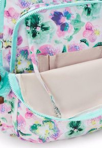 Blomstermönstrad ryggsäck med en rosa och grön design. Har ljusblå dragkedjor och en rymlig beige inre ficka med avdelare.