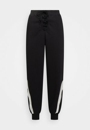 Black sweatpants with a drawstring waist, featuring a laced front, white side accents, and elastic cuffs at the ankles. Made of soft fabric.
