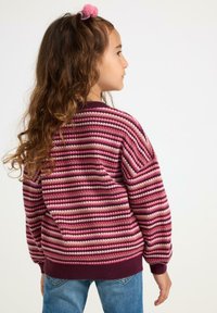 Strickpullover mit horizontalen Streifen in Rosatönen und Burgunderrot. Runder Ausschnitt, gerippte Bündchen und Saum, lockere Passform. Getragen mit blauen Jeans.