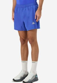 Pantaloni sportivi blu con vita elastica, caratterizzati da un piccolo logo argento sul lato sinistro, realizzati in tessuto leggero.