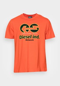 Oranges Baumwoll-T-Shirt mit einem grafischen Design in Gelb und Schwarz, das den Text "Diesel ind. Network" und ein rundes Logo enthält.