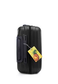 Hard-shell black suitcase with textured surface, side handle, and bright pineapple luggage tag attached. Features a zip closure.