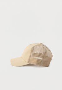 Μπεζ καπέλο μπέιζμπολ με συμπαγείς μπροστινές πλάκες και δίχτυ στις πίσω πλάκες, που βρίσκεται στο πλάι σε λευκό απλό φόντο.