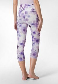 Lila blommiga capri leggings med hög midja, med en slät tygtextur och kontrasterande sömmar.