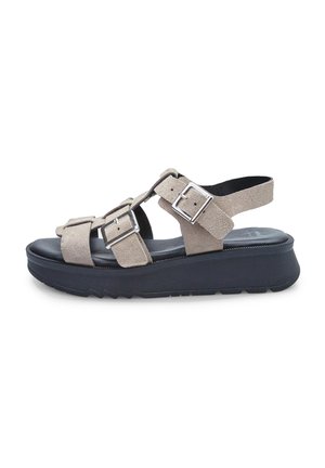 Sandali in suede beige con più cinturini regolabili, hardware in metallo argentato e una spessa suola nera a piattaforma con bordo a zigzag.