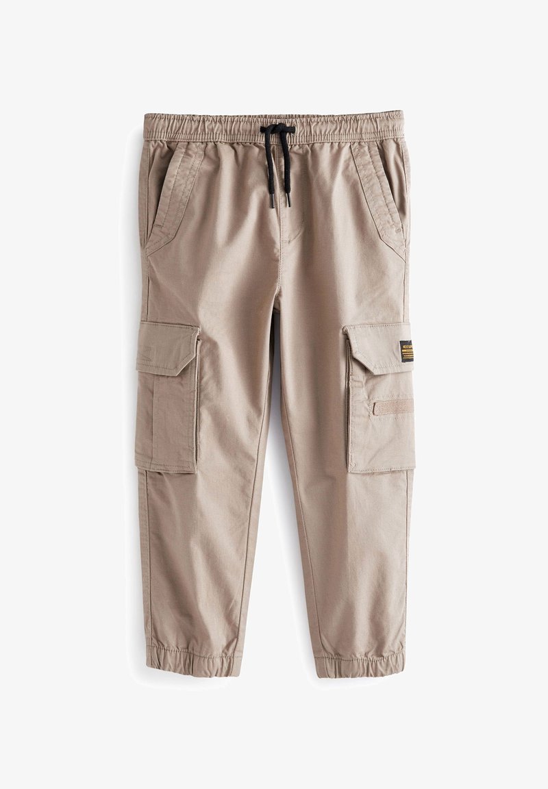 Pantalon cargo beige avec une taille élastique, un cordon de serrage ajustable, plusieurs poches latérales et des poignets resserrés. Tissu à la texture lisse.