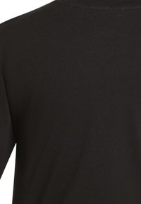 T-shirt nera in cotone con texture liscia, design a girocollo e maniche corte. La vista dall'indietro mostra una superficie piana e senza interruzioni.