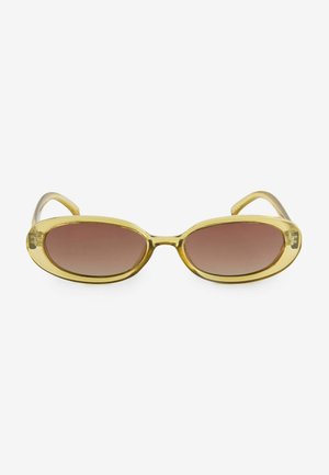 Ovale zonnebril met een gouden kunststof frame en bruine gradient glazen. Het ontwerp heeft vloeiende contouren en slanke pootjes.
