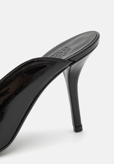 Cizmă neagră din piele lăcuită, cu toc înalt, cu o suprafață netedă, vârf ascuțit și toc subțire tip stiletto, care evidențiază un design elegant și modern.