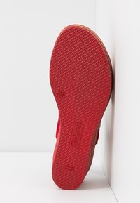 Semelle en caoutchouc rouge d’une chaussure Gabor indiquant la pointure 41,5 et le texte « Made in Portugal », avec un motif texturé antidérapant visible.
