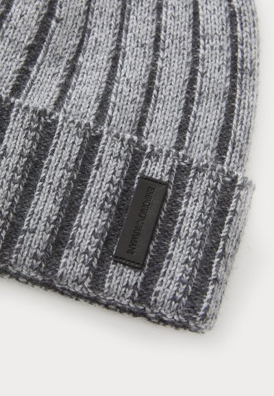 Gray and black knit beanie with a ribbed texture, featuring a leather logo patch. The design includes alternating narrow and wide stripes.