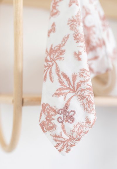 Bomullsnäsduk med blommönster i vitt och mjukt korall, prydd med detaljerade blad och en broderad detalj i hörnet.