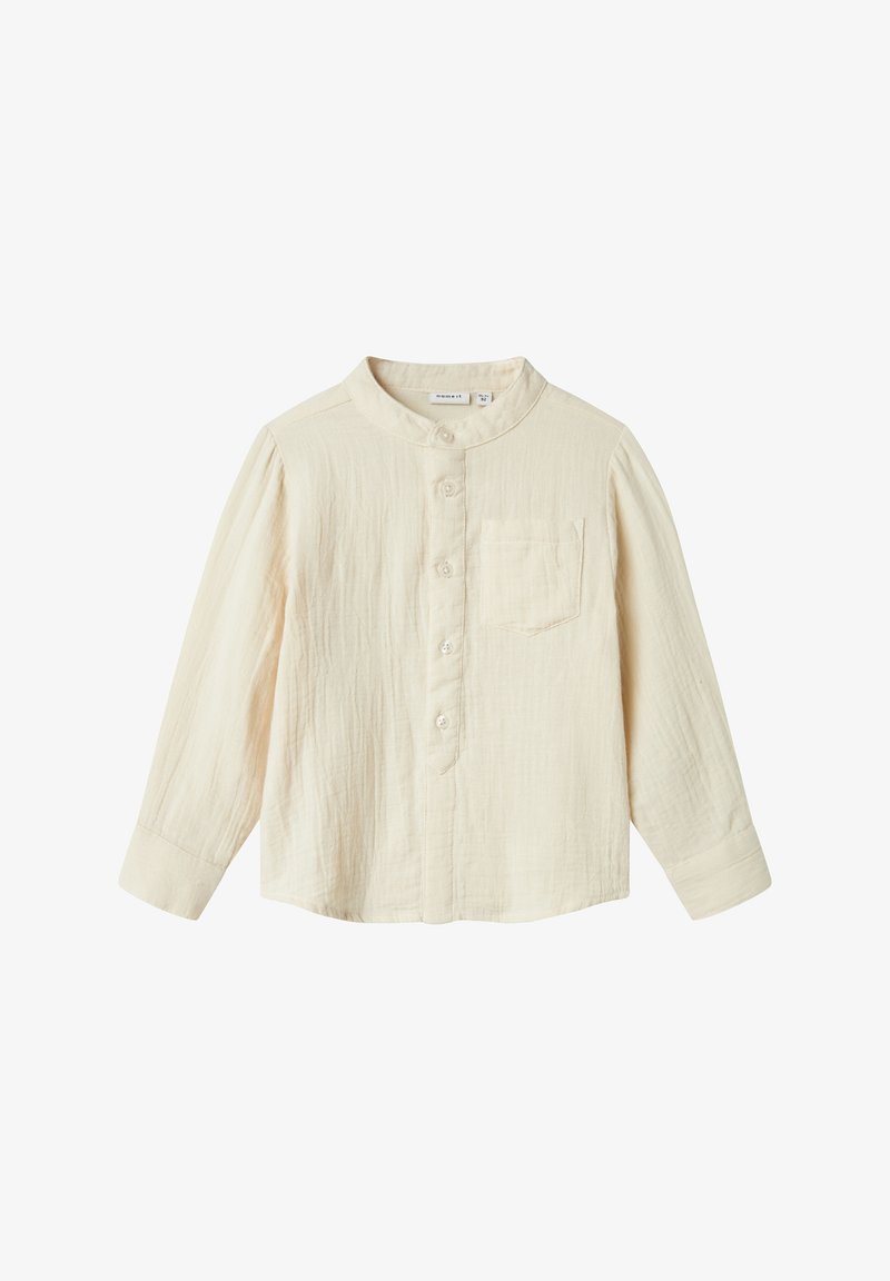 Camicia a maniche lunghe color crema chiaro in tessuto testurizzato, con patta dei bottoni, colletto alla mandarino e una piccola tasca sul petto.