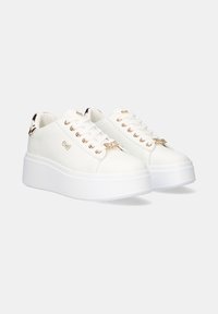 Zapatillas plataforma blancas hechas de material sintético; presentan ojales en tono dorado, marca en el costado y un acento texturizado en el talón.