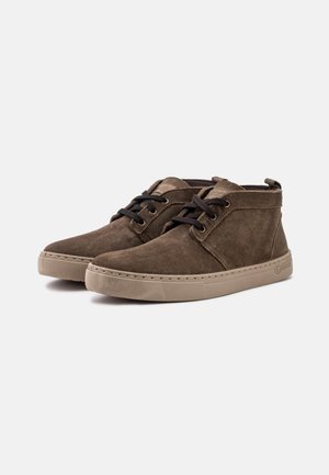 Brown suede ankle boots with round toe, lace-up design, tan rubber soles, and subtle stitching details. Tongue tag attached.