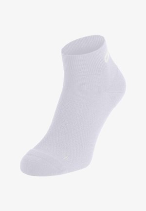 Chaussette blanche arrivant à la cheville avec un tissu texturé et un petit logo près du bord-côte et de la zone des orteils, présentée sur un fond transparent.