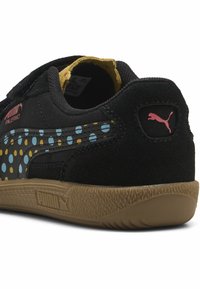 Mustade sametist tossud, millel on värvikad täpid. Omab kummist talda, takjakinnitust ja roosa Puma logo kandadel.