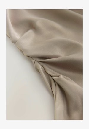 Beige selyem anyag sima felülettel, csavart részekkel, amelyek lágy redőket és finom fényt hoznak létre.