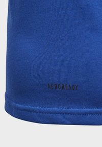 Camiseta atlética azul con una textura suave, tejido transpirable y un distintivo logo negro "AEROREADY" cerca del dobladillo.