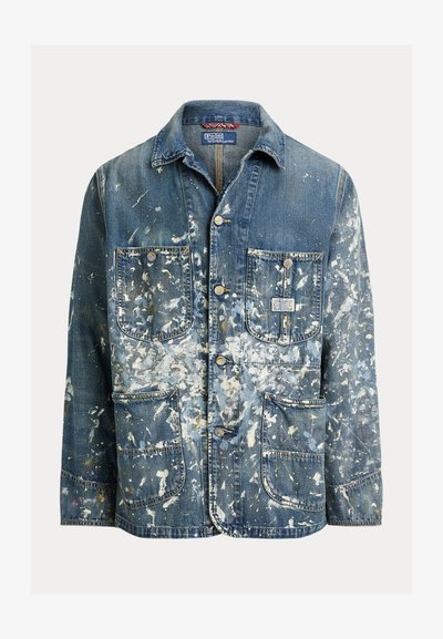 Μπουφάν από τζιν με τέσσερις μπροστινές τσέπες, κλείσιμο με κουμπιά και σχέδιο με πιτσιλιές λευκής μπογιάς σε όλο το ύφασμα.