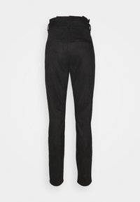 Pantalon noir taille haute, coupe slim, avec passants pour ceinture, poches passepoilées à l'arrière, et jambes fuselées.