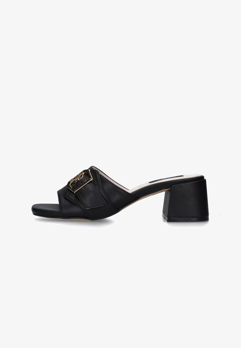 Sandali con tacco in pelle nera con una fascia larga e un dettaglio in fibbia dorata, progettati per essere indossati facilmente.