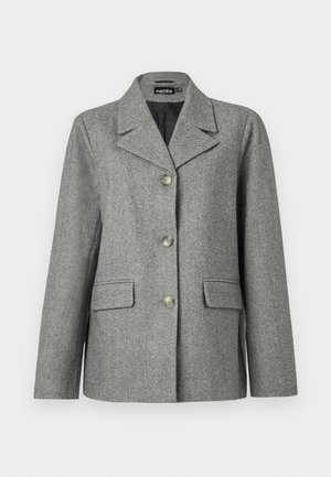 Harmaa herringbone-takkia, jossa on hihansuut ja kolme nappia, kaksi etutaskua ja muodollinen leikkaus. Sileä kangas ja räätälöity muotoilu.
