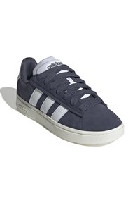 Mörkblå mockaskor med vit tre-stripsdesign, rund tå, vadderad krage och vit gummisula. Har snörning.