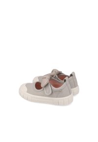 Zapatillas de lona gris con puntera redonda, gran lazo en la parte superior, suela de goma contrastante y recortes circulares en los laterales.