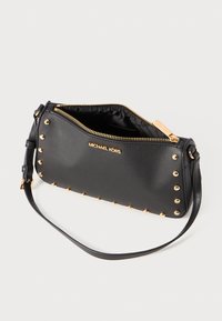 Black synthetic crossbody bag with gold-tone studs and hardware, zip closure, and an adjustable strap. Smooth texture, sleek design.