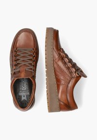 Baskets en cuir marron avec un design à coutures, semelle en caoutchouc, fermeture à lacets, et une étiquette indiquant "Origine" sur le côté.